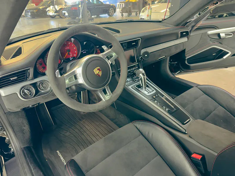 The customized interior of a Porsche 911 featuring suede leather in the Superior Autohaus garage.