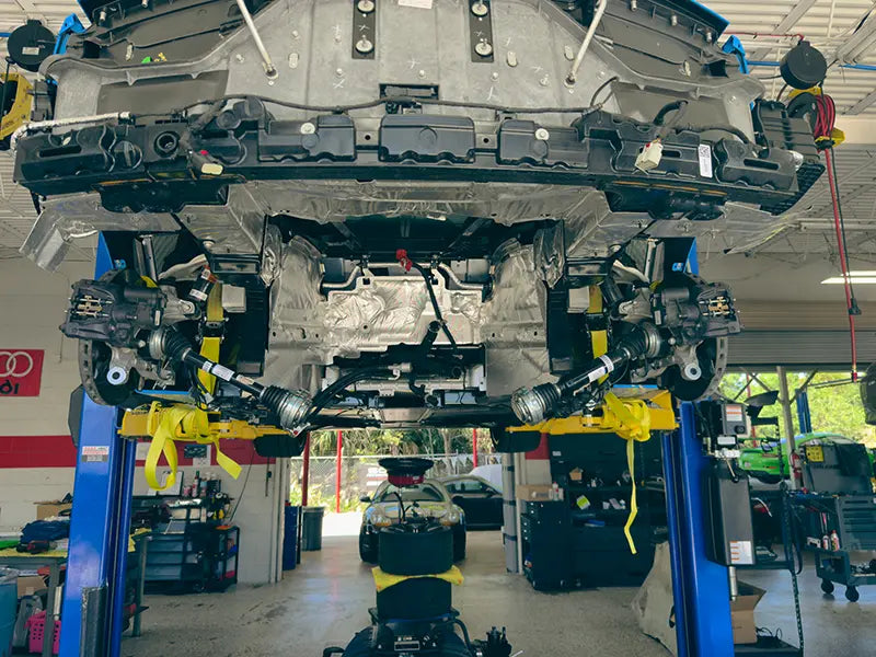 The body of a car up on a lift in the Superior Autohaus garage for custom suspension upgrades.
