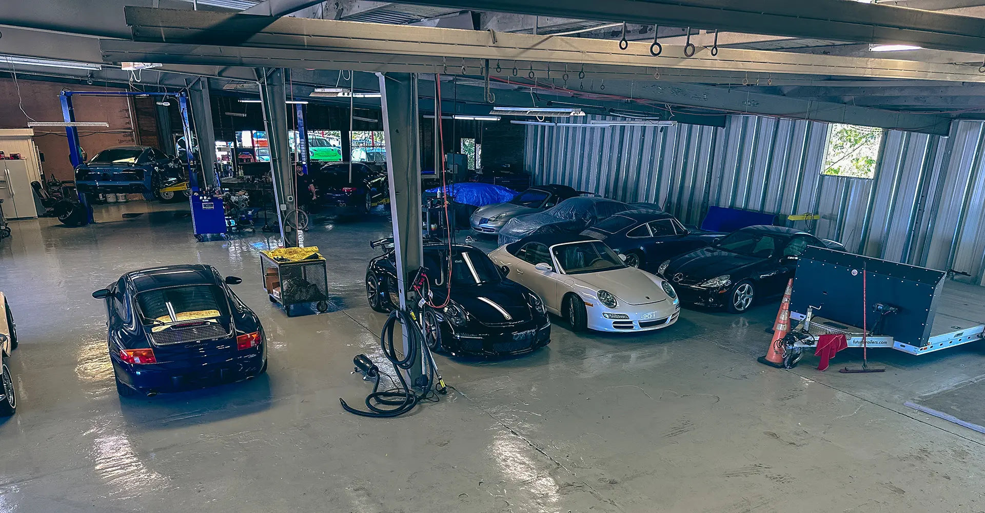 Overview of the interior of the Superior Autohaus garage, lined with sports cars and organized equipment.