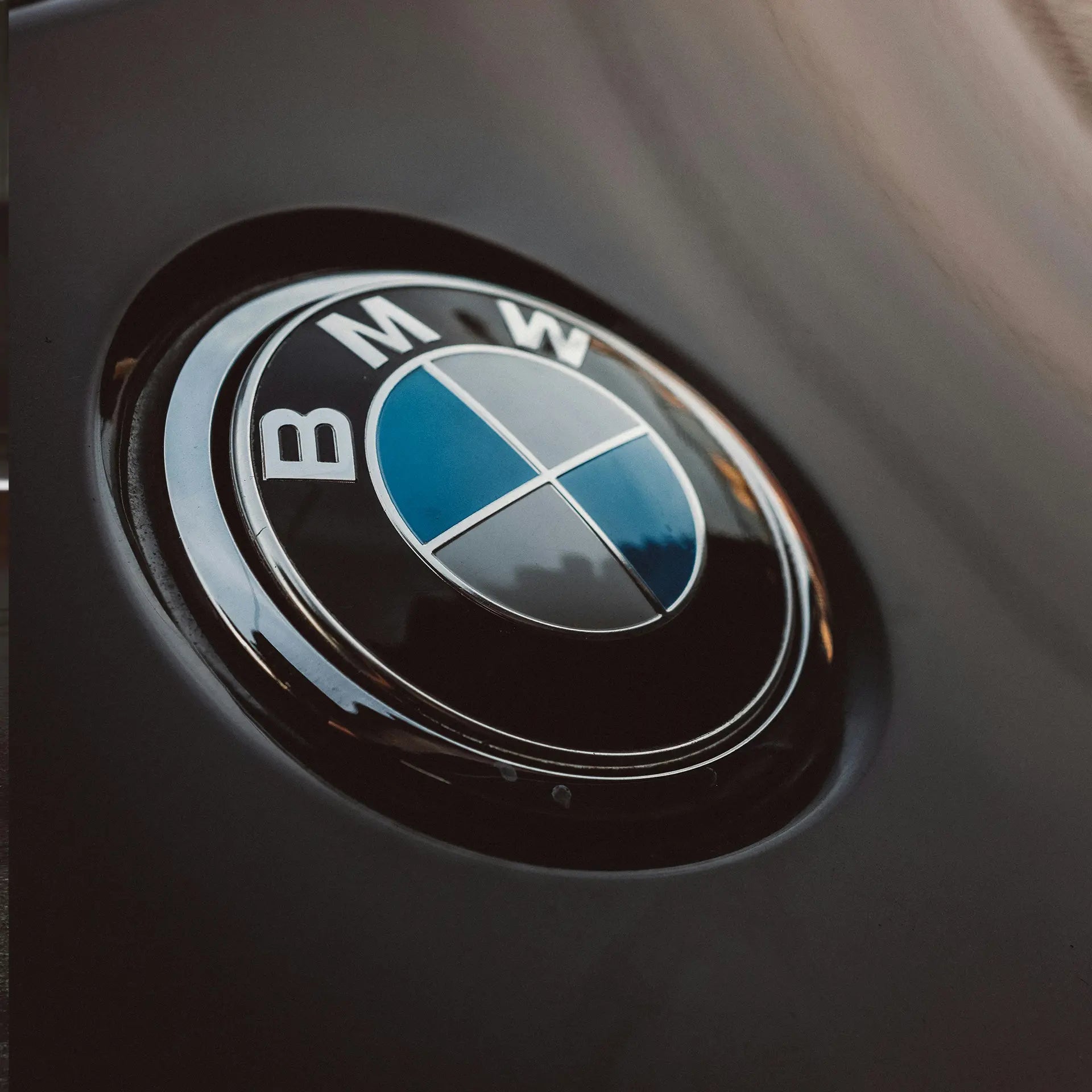 The BMW logo medallion on the hood of a car. 