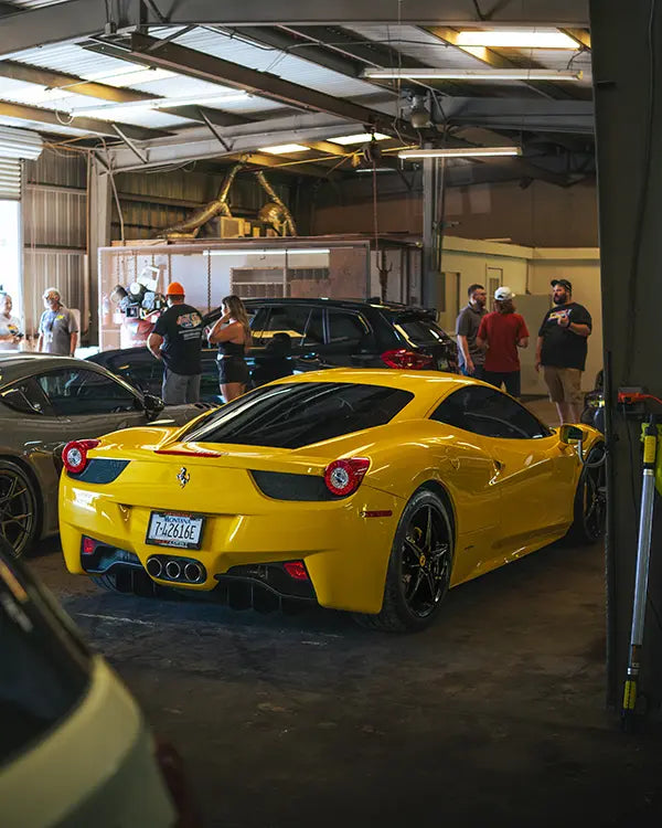 A yellow Ferrari parked inside the Superior Autohaus garage for event attendees to view and admire. 